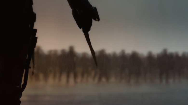 Un guerrier tenant un couteau face à une ligne de bataille