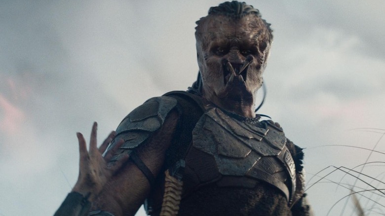 Dek regarde une main tendue vers l'intérieur. 