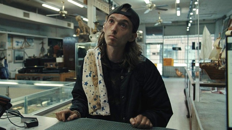 James debout dans le prêteur sur gages dans Weapons