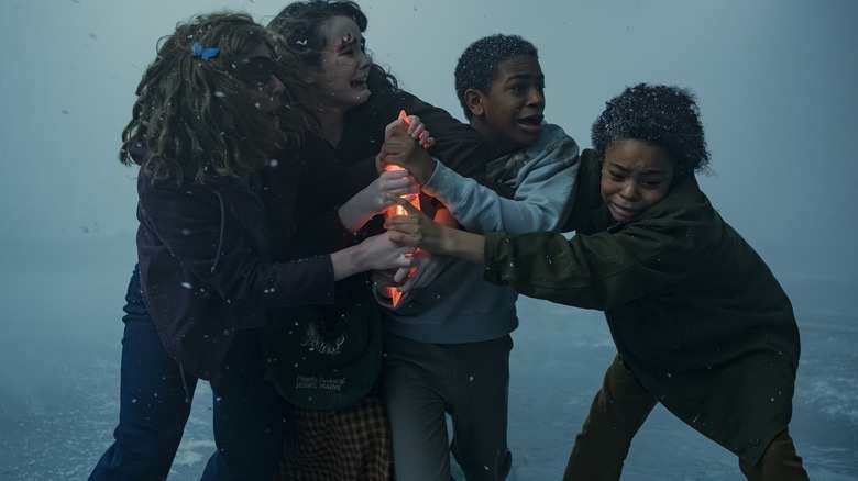 Marge, Ronnie, Lilly et Will tenant un artefact lumineux dessus : Bienvenue à Derry