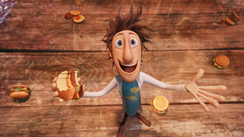 Le personnage animé Flint sourit avec un hamburger à la main dans Cloudy With a Chance of Meatballs