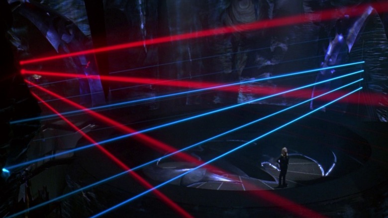 Barbara debout dans la Bat Cave entourée de lasers dans Batman & Robin (1997)