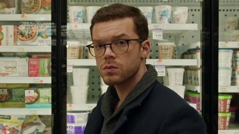 Chris debout devant le congélateur d'un magasin dans Shattered (2022)