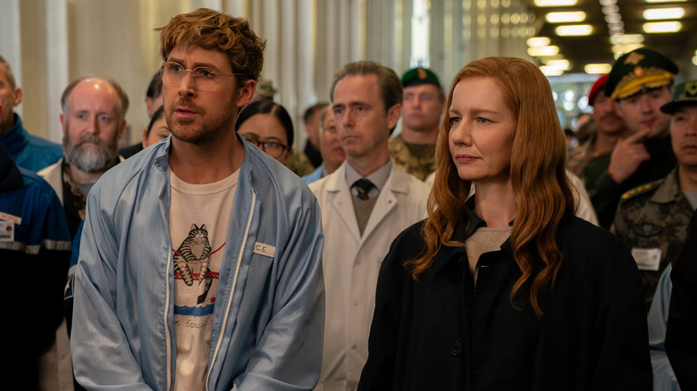 Ryland et Eva debout devant des scientifiques dans le cadre du projet Hail Mary