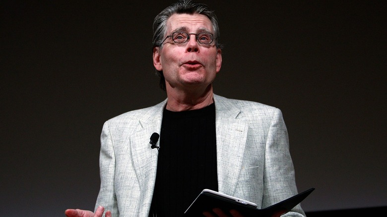 Stephen King sur scène lisant sur un Kindle