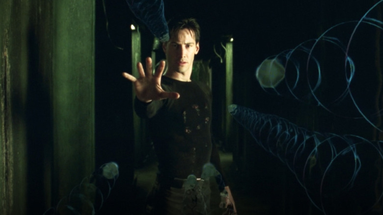Keanu Reeves dans le rôle de Neo arrêtant les balles dans Matrix
