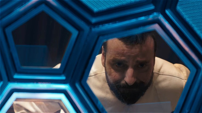 Zor-El a l'air triste à travers la fenêtre dans le film Supergirl