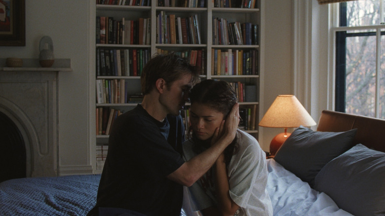 Charlie embrasse Emma assise sur leur lit 