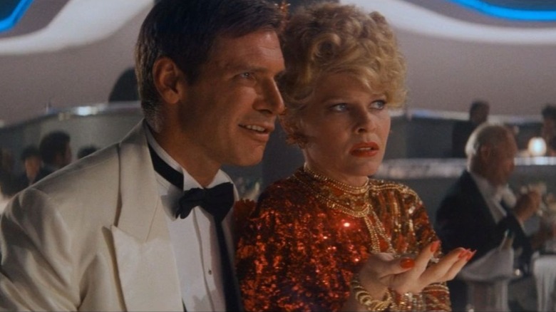 Indiana Jones est assis à côté de Willie Scott dans une discothèque dans Indiana Jones et le Temple maudit (1984)