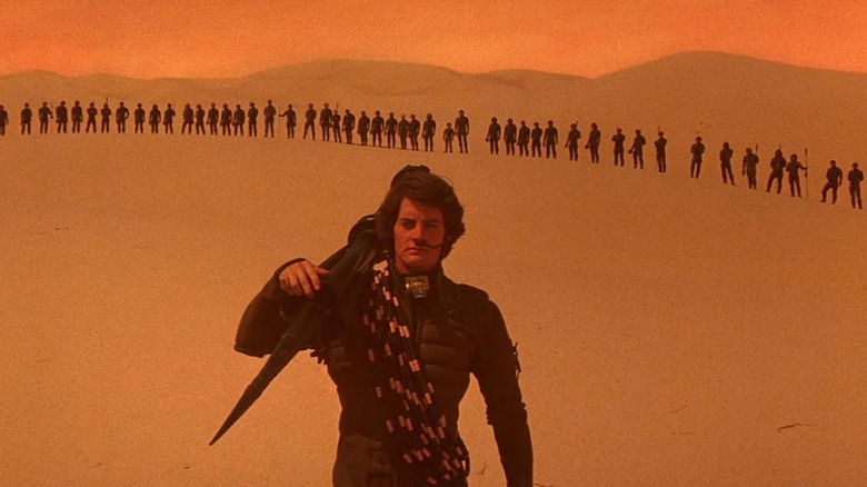 Paul Atreides se tient devant une ligne de Fremen dans les sables d'Arrakis