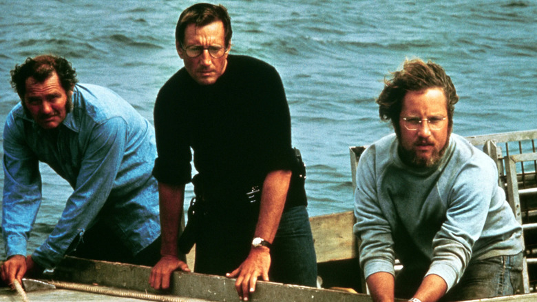 Brody, Hooper et Quint penchés sur le bord d'un bateau