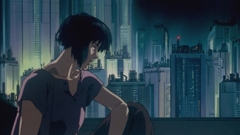 Major Kusanagi assis devant un paysage urbain futuriste 