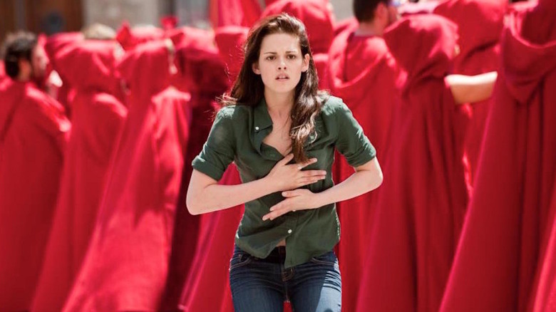 Bella courant à travers une foule vêtue de manteaux rouges dans The Twilight Saga : New Moon
