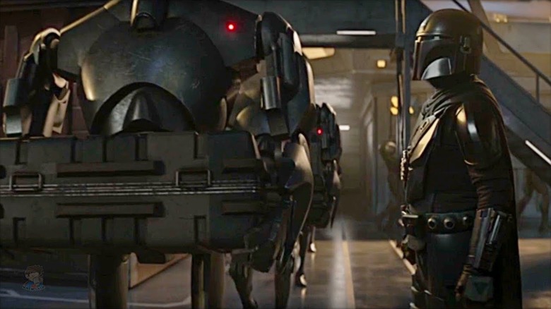 Din Djarin regarde d'un air désobligeant un groupe de droïdes de combat B2 dans The Mandalorian (2023)