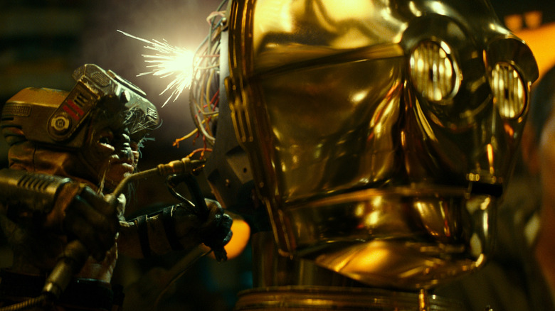 Babu Frik perce l'arrière de la tête de C-3PO dans Star Wars : Épisode IX - L'Ascension de Skywalker (2019)