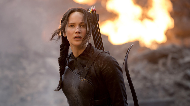 Katniss a l'air choquée devant une explosion dans The Hunger Games : Mockingjay – Partie 1