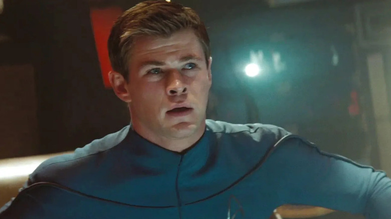 Le lieutenant George Kirk regarde avec inquiétude à bord d'un vaisseau spatial dans son uniforme bleu de Starfleet 