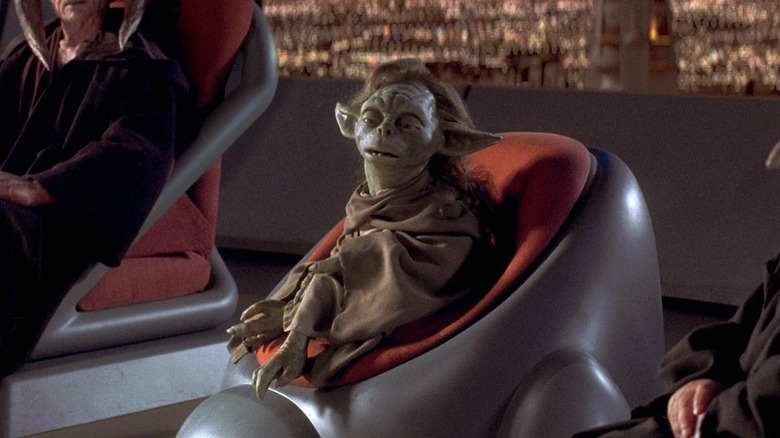 Yaddle assise à son siège au Conseil Jedi lors d'une réunion en soirée dans Star Wars : Épisode I - La Menace Fantôme (1999)