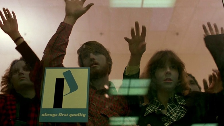 Des zombies frappent sur la porte vitrée du centre commercial de Monroeville dans Dawn of the Dead