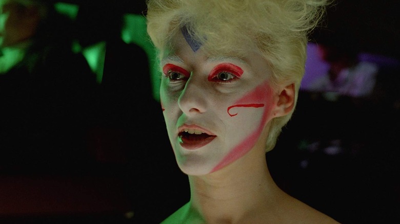 Margaret parlant avec du maquillage blanc, rouge et bleu dans Liquid Sky (1982)