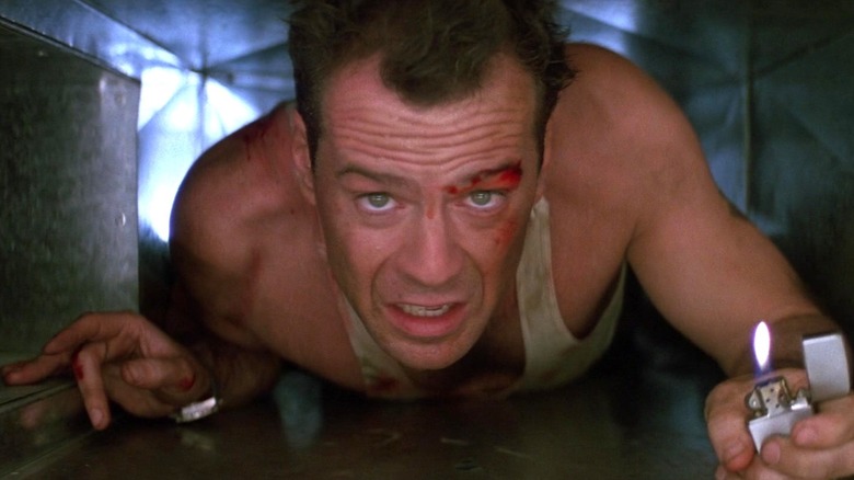 John McClane tenant un briquet dans Die Hard (1988)