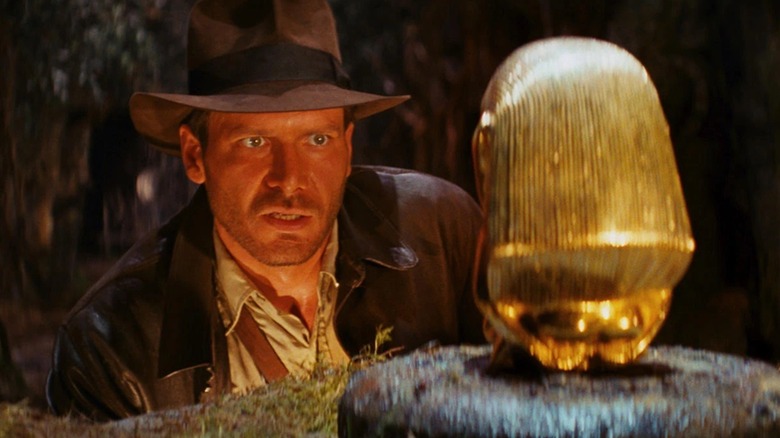 Indiana Jones inspectant une idole en or 