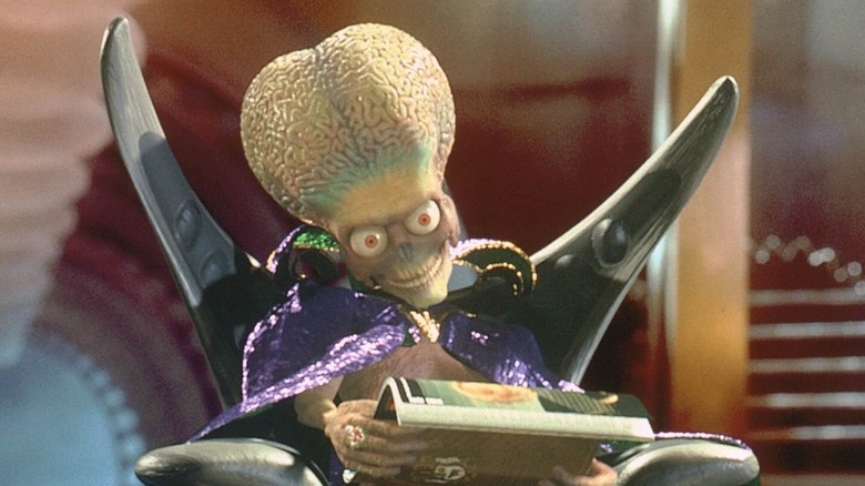 Un Martien inspectant un magazine terrestre dans Mars Attacks ! (1996)