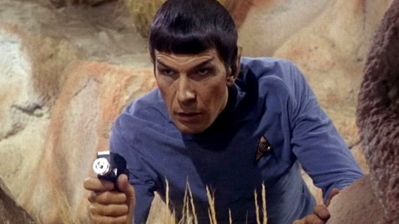 Spock s'accroupit tout en pointant son phaseur dans Star Trek : la série originale (1966)