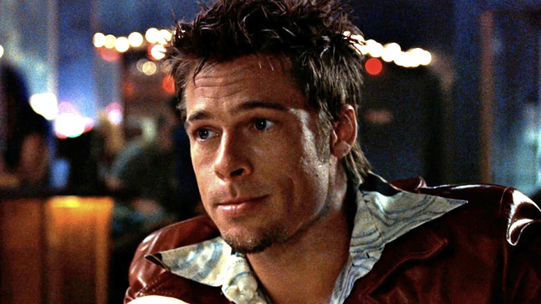 Tyler Durden est assis et sourit au Fight Club