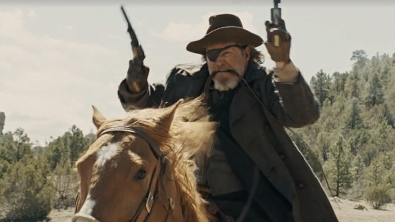 Coq Cogburn à cheval avec deux fusils 