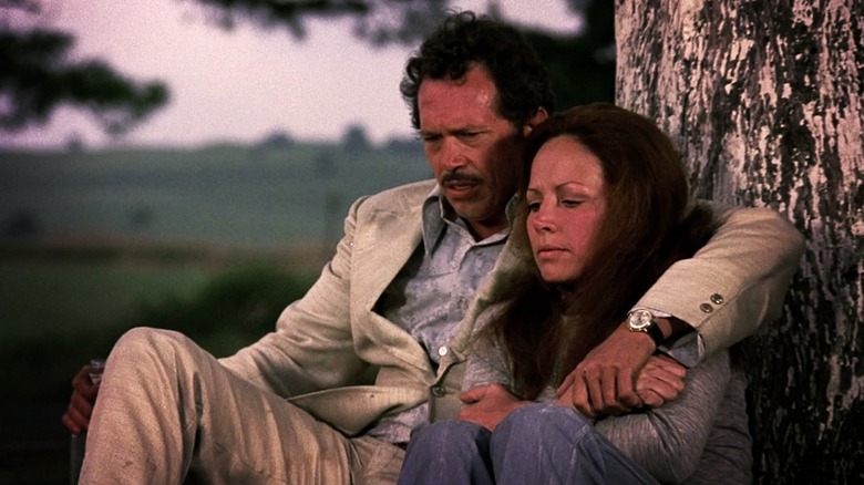 Bennie et Elita assis près d'un arbre dans Bring Me The Head d'Alfredo Garcia (1974)