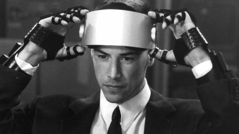 Johnny enfile un équipement d'interface numérique dans Johnny Mnemonic (1995)