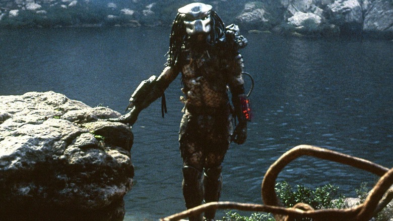 Le Predator debout près d'un lac dans Predator (1987)