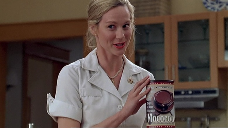 La femme de Truman brandissant une boîte de mélange Mococoa dans la cuisine dans The Truman Show
