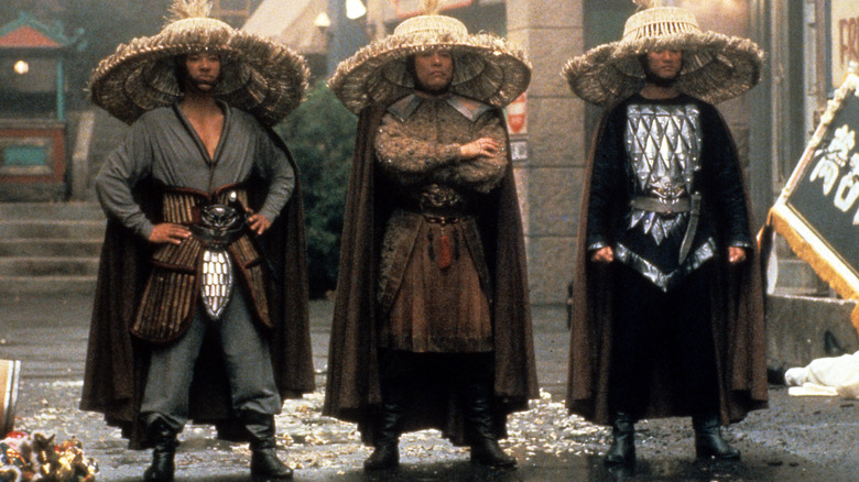 Trois hommes debout portant de grands chapeaux en osier dans Big Trouble in Little China (1986)