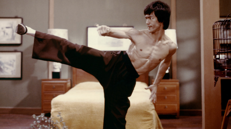 Lee donne un coup de pied près d'un lit dans Enter the Dragon (1973)