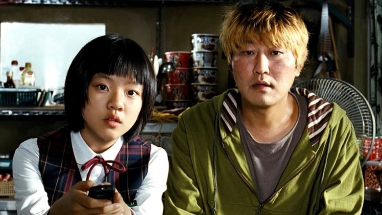 Gang-du et Hyun-seo assis ensemble sur le canapé dans The Host