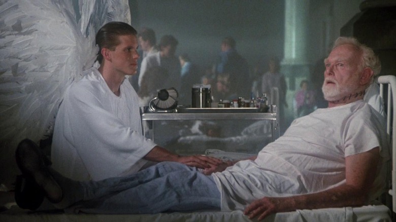 Un ange assis au chevet du père Tom Kanavan, qui a des points de suture au cou comme si sa tête avait été refixée, dans L'Exorciste III