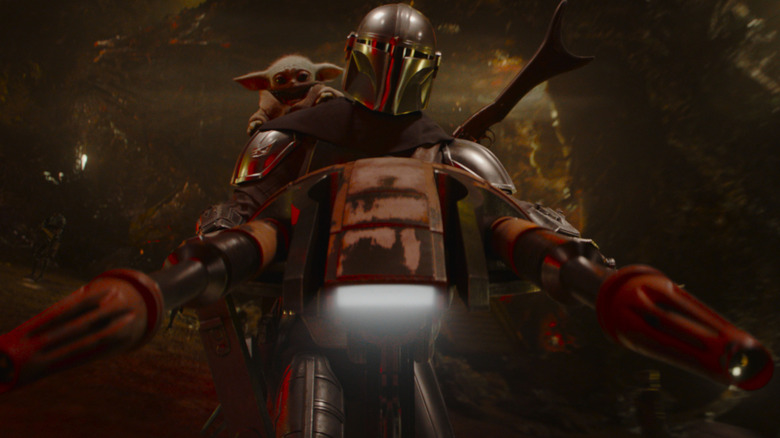 Din Djarin sur un vélo spatial avec Grogu sur son épaule dans The Mandalorian et Grogu