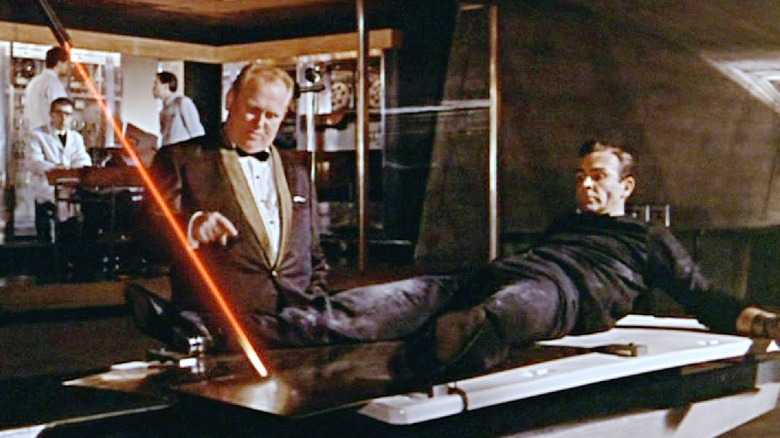 James Bond sur la table tandis que Goldfinger explique le laser dans 