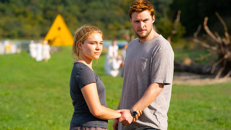 Dani et Christian se tiennent la main et regardent quelque chose à Midsommar