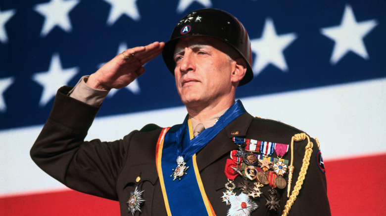 Le général Patton salue devant un drapeau américain dans 