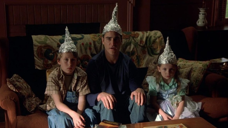 Morgan, Merrill et Bo assis sur le canapé avec des chapeaux en aluminium. 