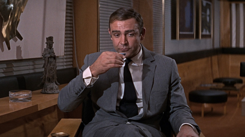 Sean Connery dans le rôle de James Bond en train de boire