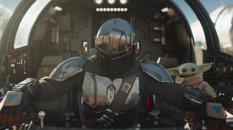 Din Djarin pilotant un chasseur stellaire avec Grogu sur le siège passager dans The Mandalorian et Grogu