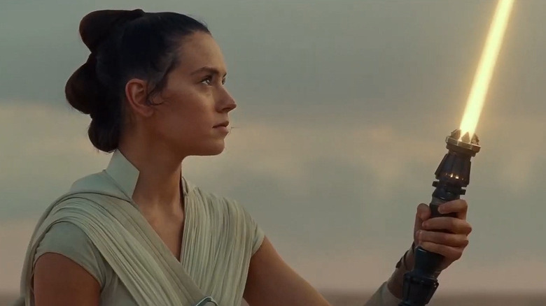 Rey allumant son sabre laser jaune dans la scène finale de la saga Skywalker