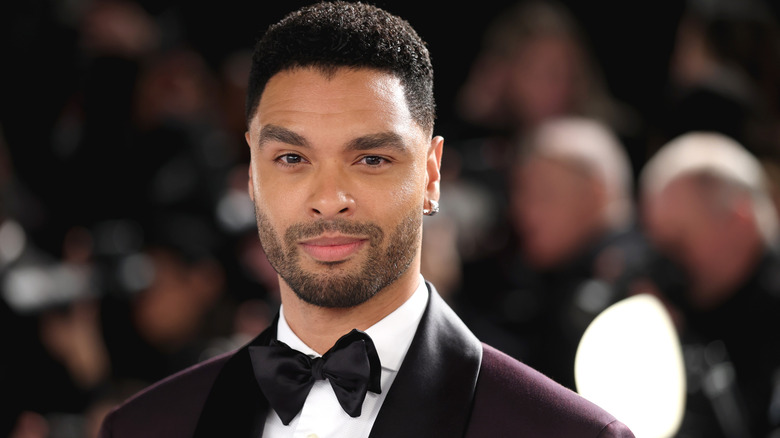 Gros plan de l'acteur Regé-Jean Page portant un smoking et souriant