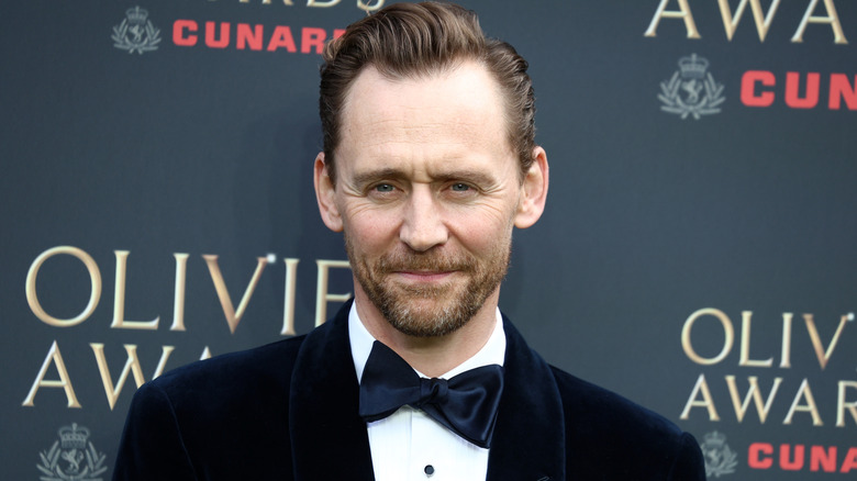 Gros plan de l'acteur Tom Hiddleston posant en smoking aux Olivier Awards