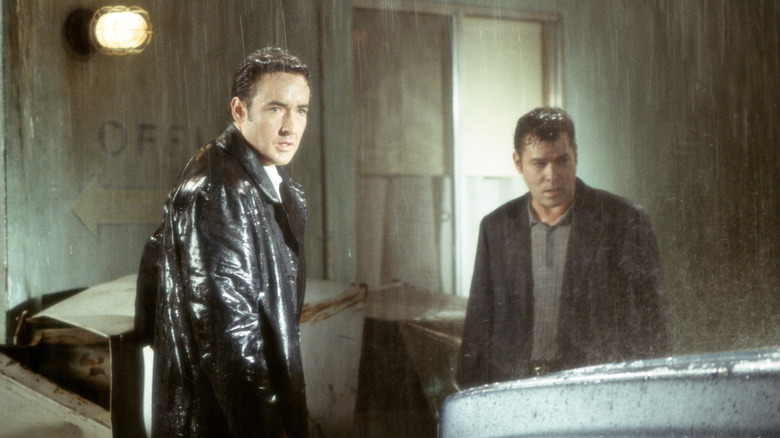 Ed et Rhodes debout sous la pluie devant le motel à 
