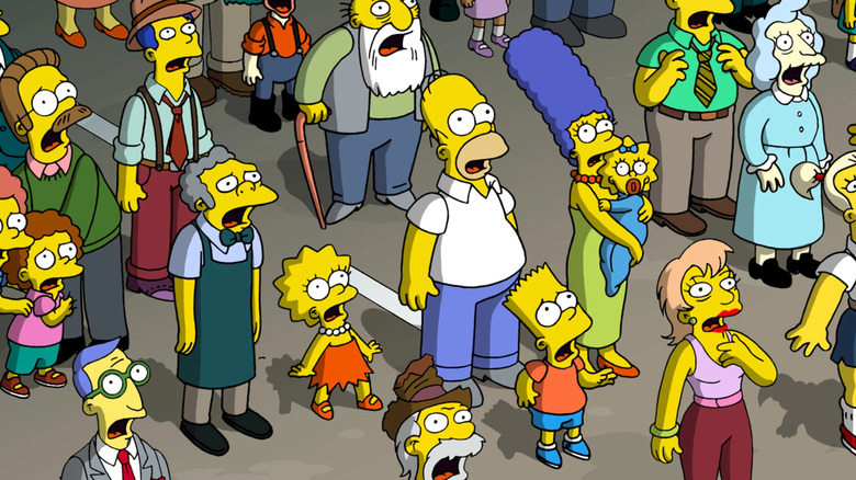 Les Simpsons et les habitants de Springfield levant les yeux sous le choc dans Le film Les Simpsons (2007)